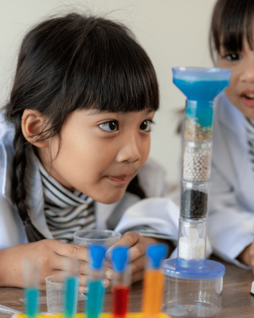 Little girl doing a science experiment and looking at it