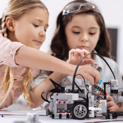 Two girls building a robot